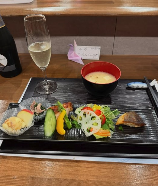 A market breakfast set with grilled fish, pickles, miso soup and a glass of sparkling wine