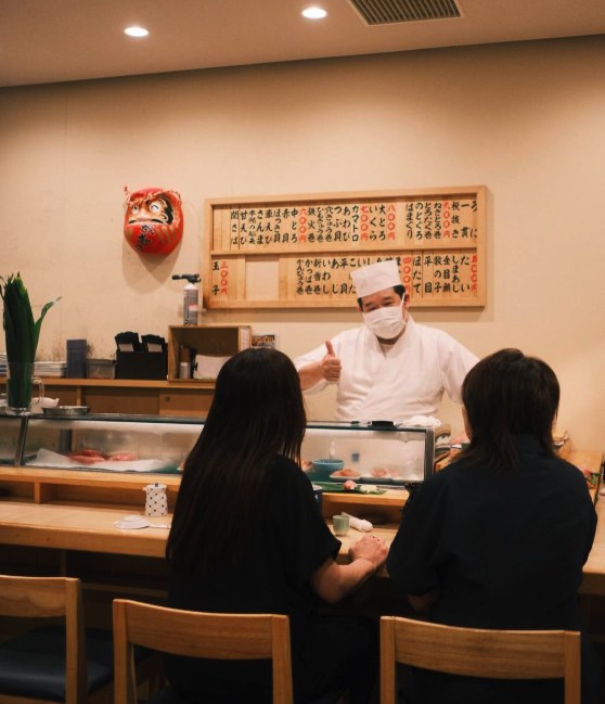 A sushi counter in service, the chef working directly across from the seats