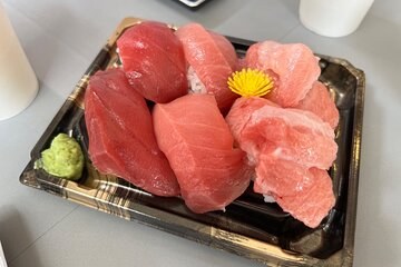 A tray of tuna sashimi cut to order, with a curl of grated wasabi