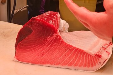 A tuna loin cut back to the belly, the pale fat running through the red flesh