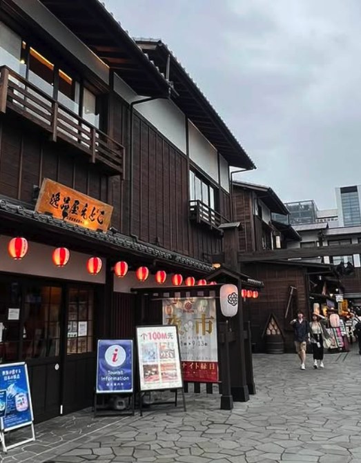 The wooden shopfronts and red lanterns of the Edo-style shopping street beside Toyosu Market